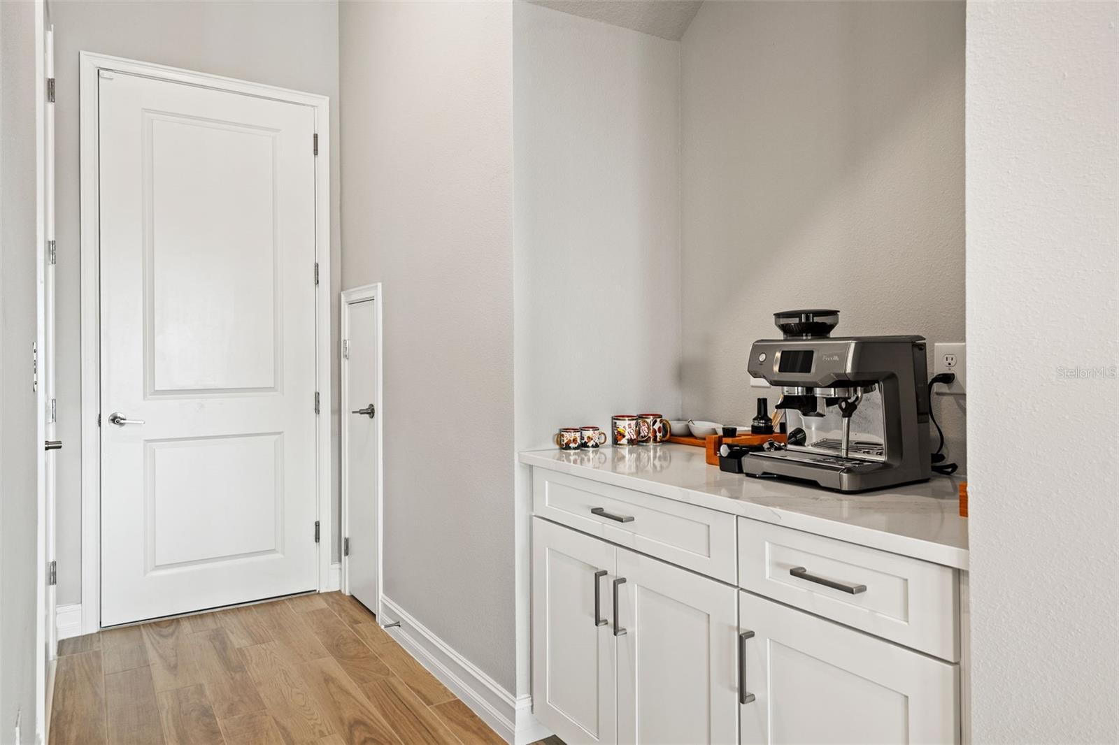 Dry bar with storage adjacent to kitchen