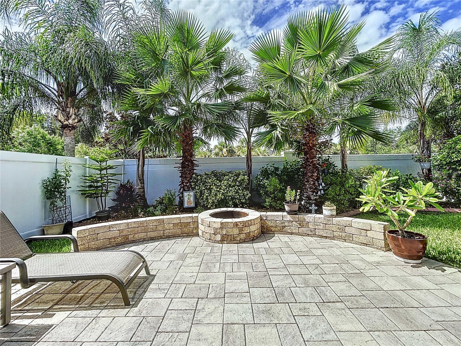 Rear brick paver patio with built-in fire pit