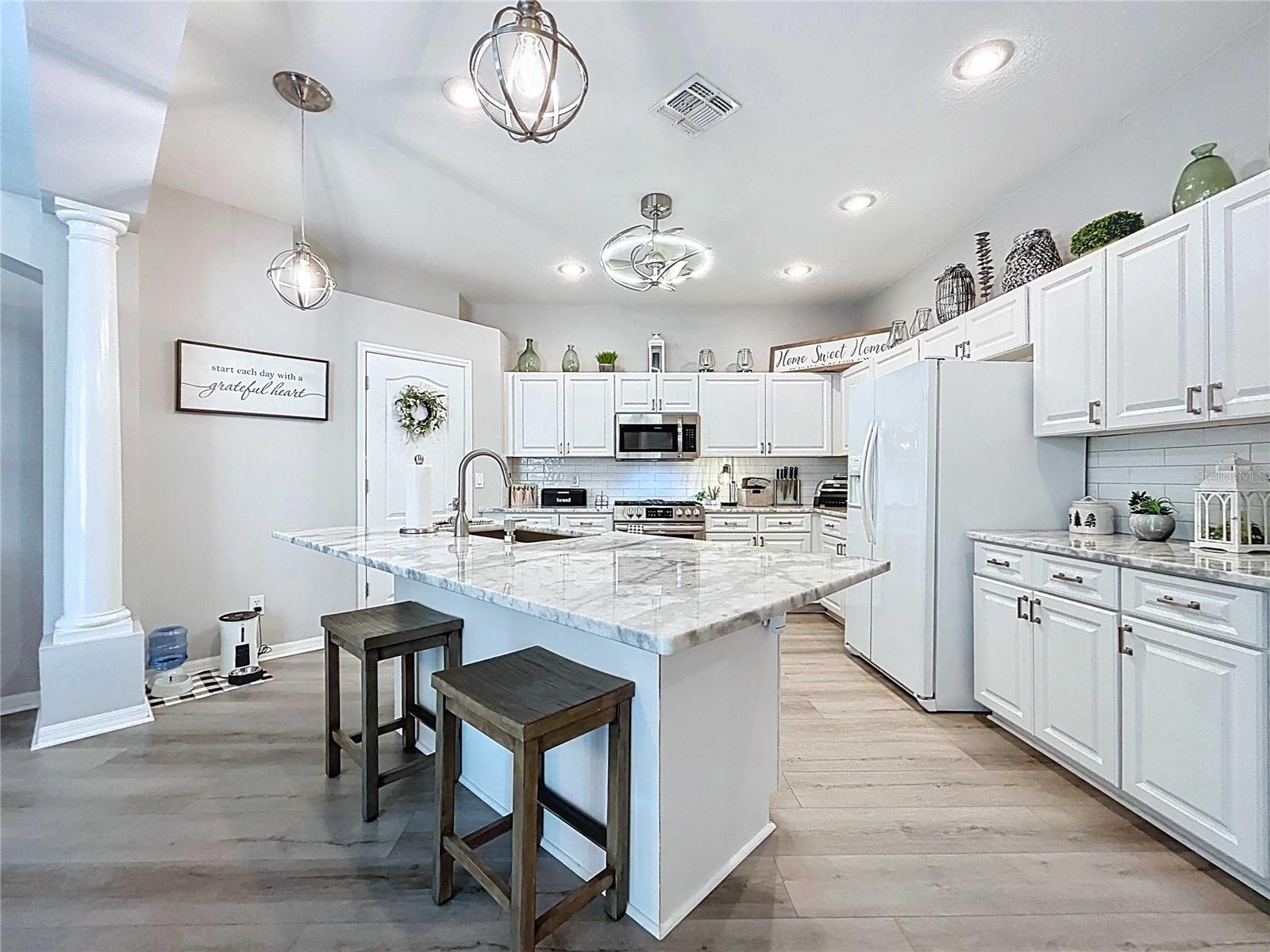 Eat-in bar stools in kitchen with pendant lighting