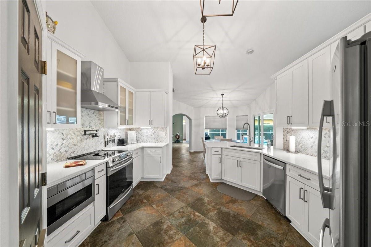 Spacious kitchen with quartz countertops and custom hood