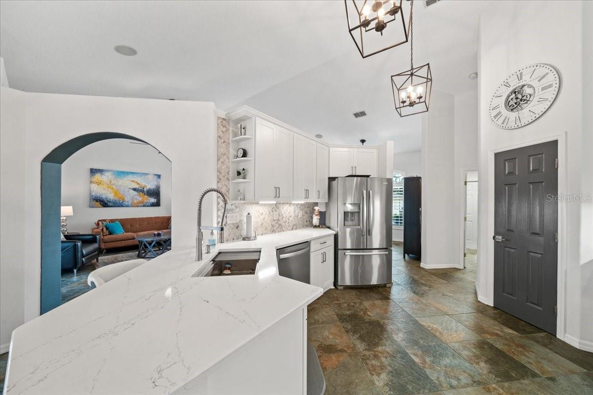 Spacious kitchen with quartz countertops and custom hood