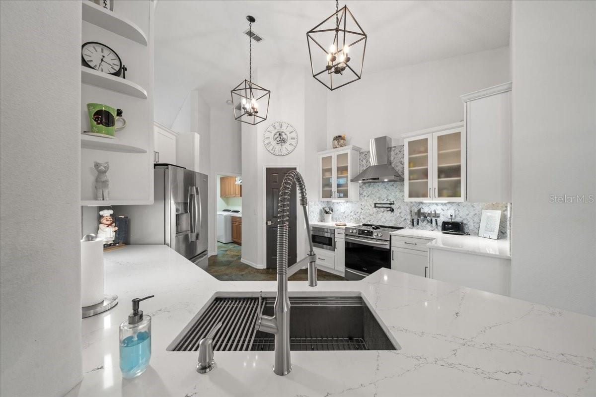 Spacious kitchen with quartz countertops and custom hood