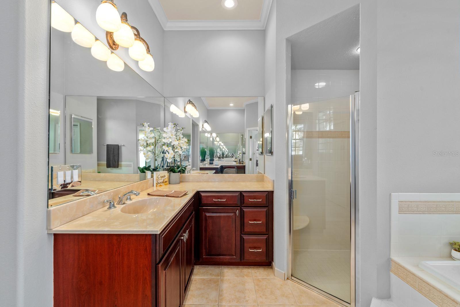 The primary ensuite features crown molding, a walk-in shower, large soaking tub, private water closet, and two separate vanities with sinks and extensive counter space!