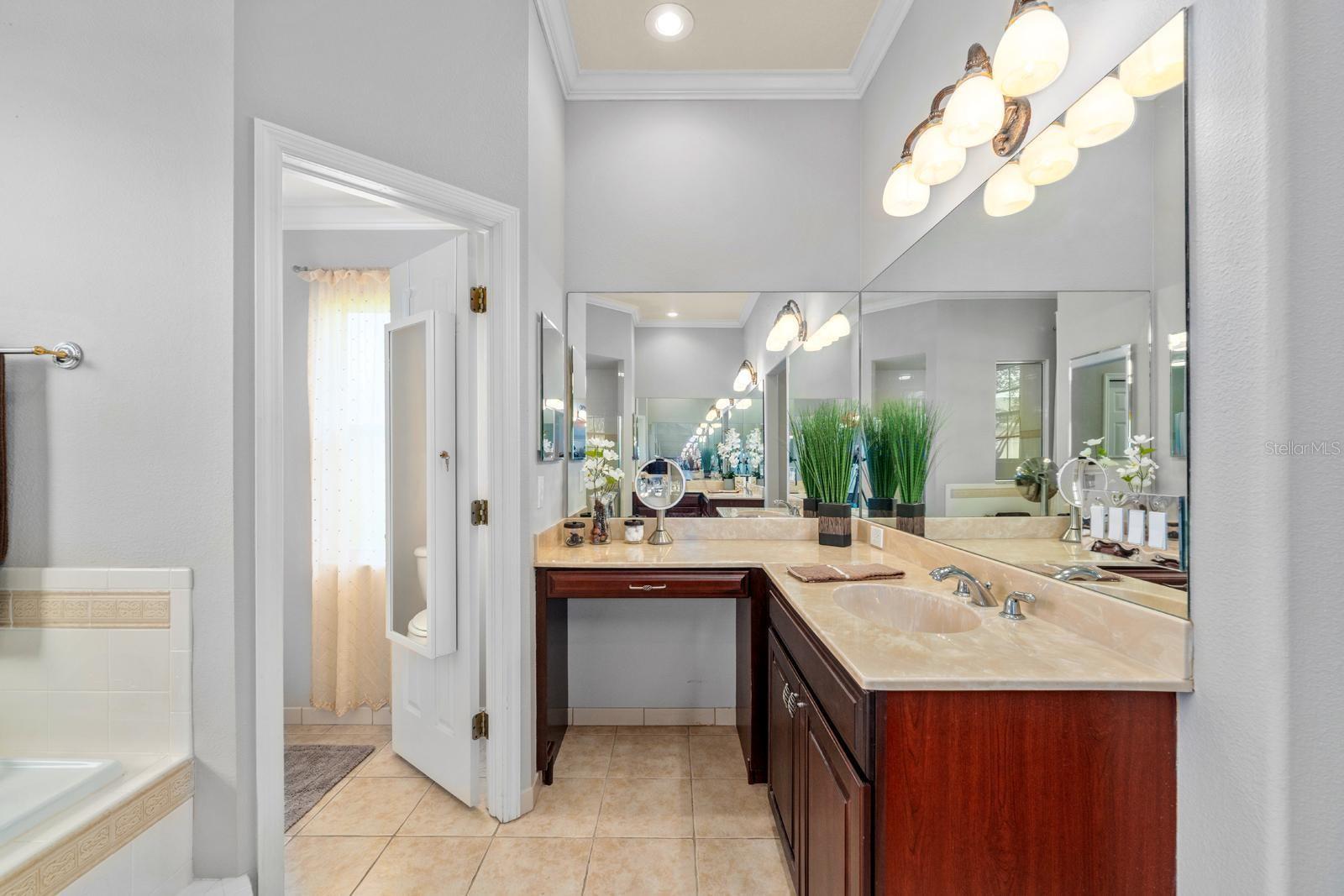 The primary ensuite features crown molding, a walk-in shower, large soaking tub, private water closet, and two separate vanities with sinks and extensive counter space!