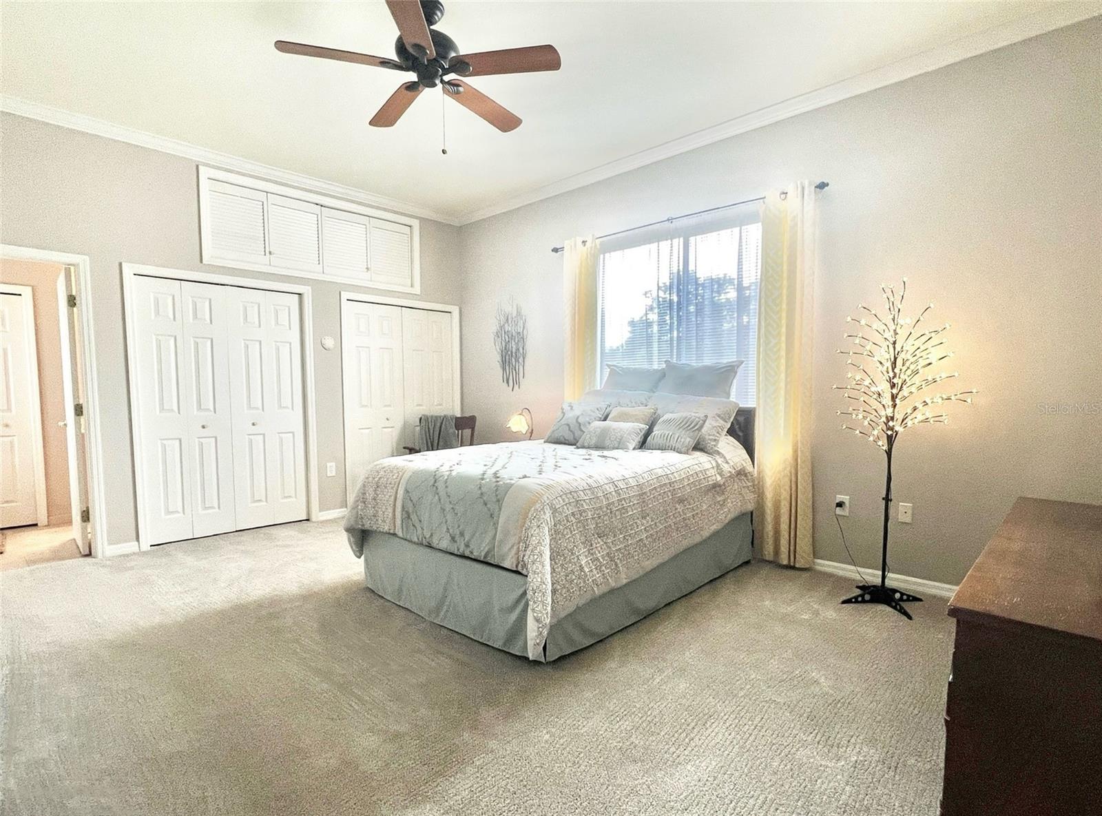 Bedroom 2 is extra large and has its OWN BATHROOM!  This bedroom features crown molding, extremely clean carpet, a ceiling fan, 2 large closets, plus extra storage space above the closets, and a large window.  To the far left is the door to the full bathroom.