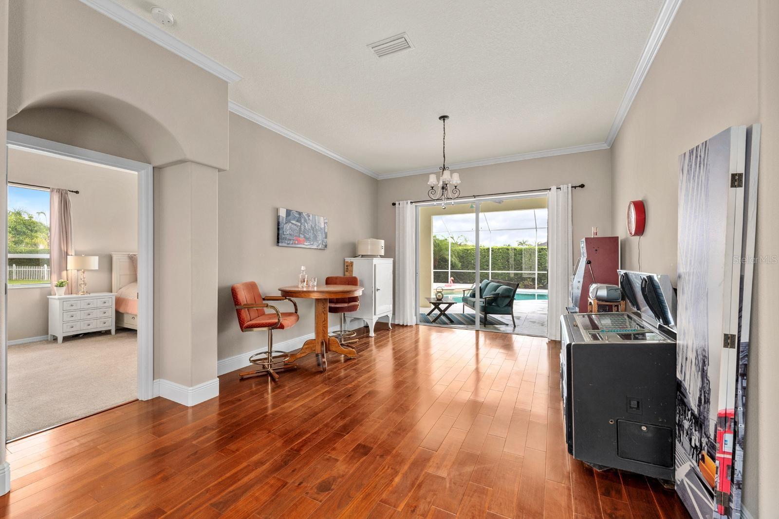 When you enter through the front door, you'll immediately notice the pool through the large 8' tall sliding glass door....and the 10' tall ceilings, 5-1/4" baseboards, and hardwood floors.  The current owner has made this into a game room.