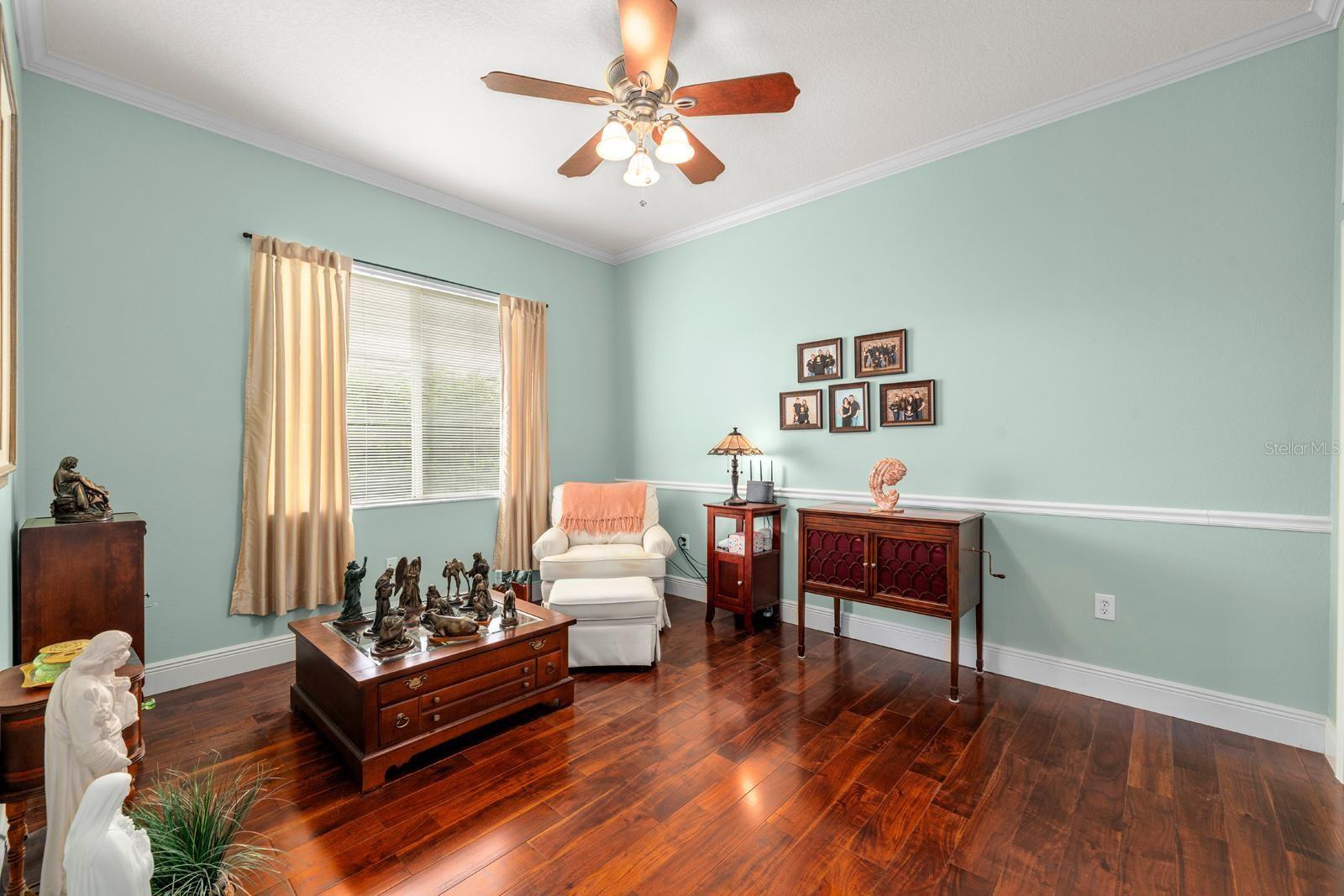 Bedroom 3 is large and features crown molding, hardwood floors, updated baseboards, a lighted fan, extra storage space above the double closet, and a large window.