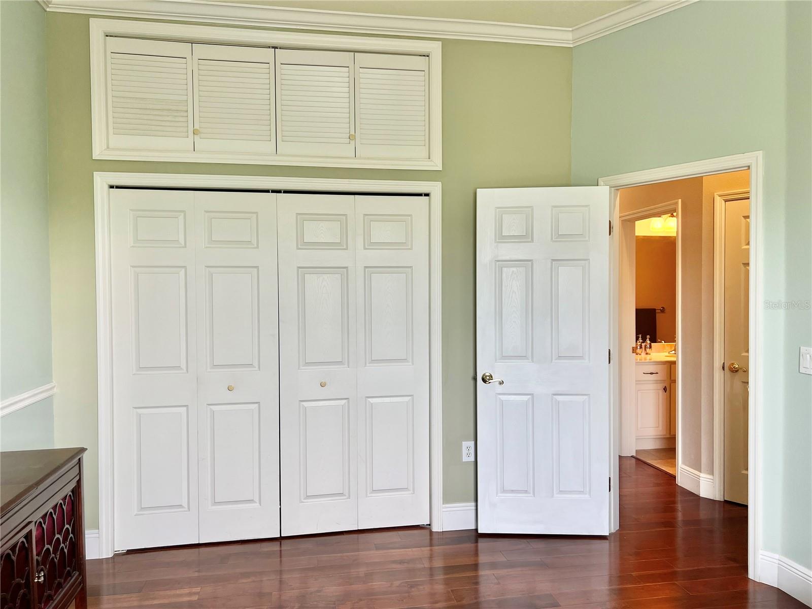 Bedroom 3 is large and features crown molding, hardwood flooring, updated baseboards, a lighted fan, extra storage space above the double closet, and a large window.