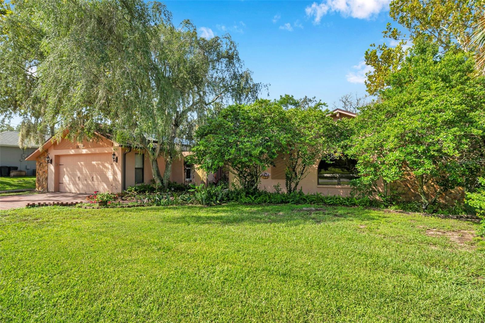 Impressive home with wide driveway, solar panels, private entrance with peaceful pond and rock stream on a corner homesite with no immediate neighbors on the side or across the street.
