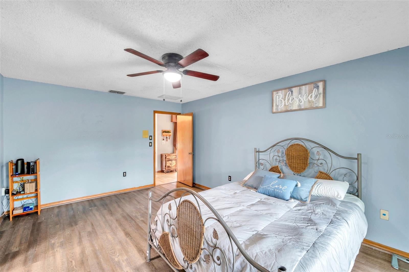 Primary bedroom features a Sliding Glass Doors to the Pool/Patio, Ensuite Bathroom, Ceiling Fan, and large Walk-In Closet