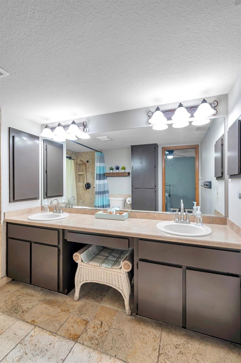 Primary bathroom with double sinks and a walk in shower