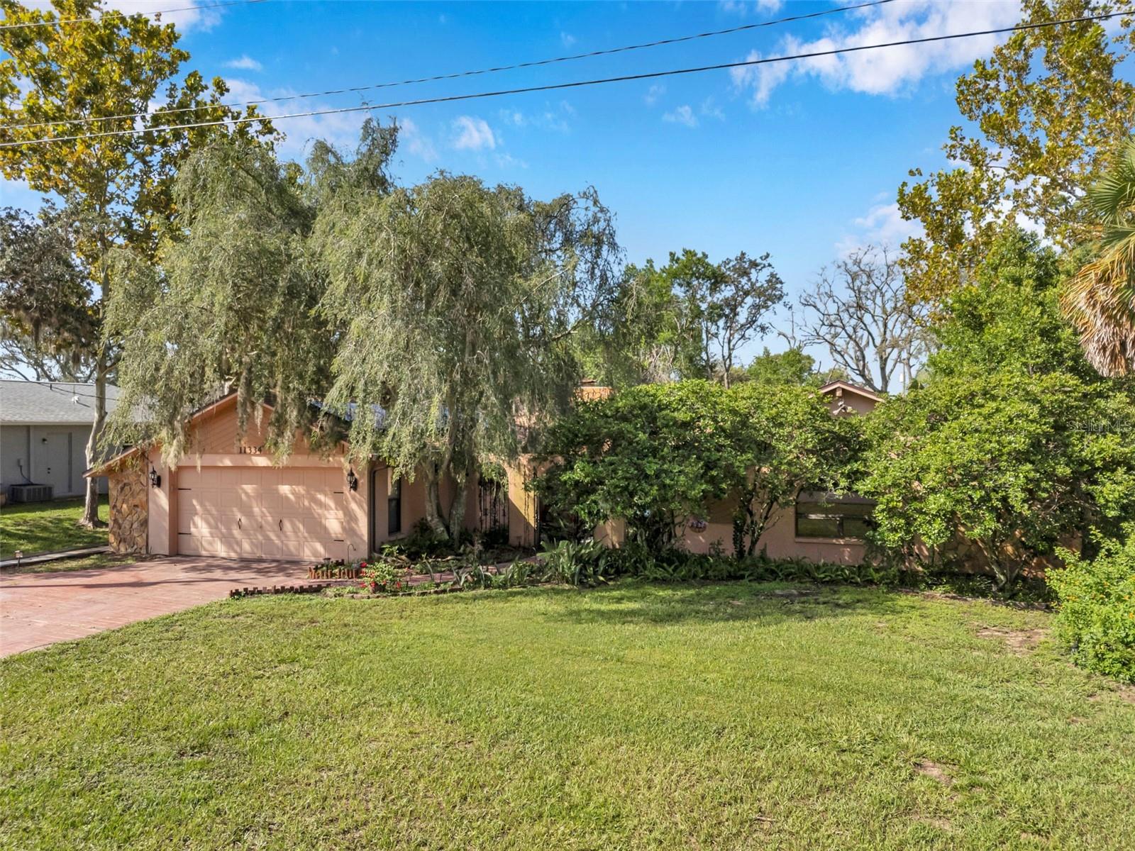 Impressive pool home with wide driveway, solar panels, private entrance with peaceful pond and rock stream on a corner homesite with no immediate neighbors across the side street.