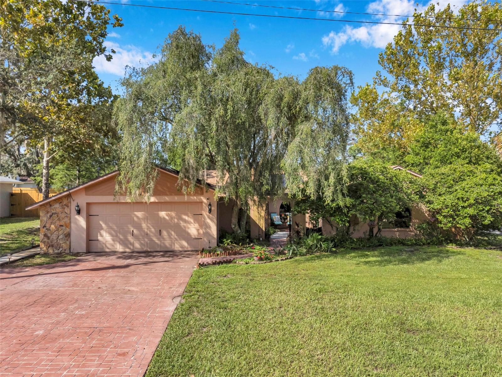 Impressive pool home with wide driveway, solar panels, private entrance with peaceful pond and rock stream on a corner homesite with no immediate neighbors across the side street.
