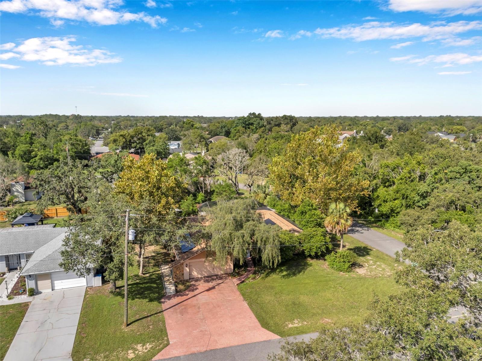 Impressive pool home with wide driveway, solar panels, private entrance with peaceful pond and rock stream on a corner homesite with no immediate neighbors across the side street.