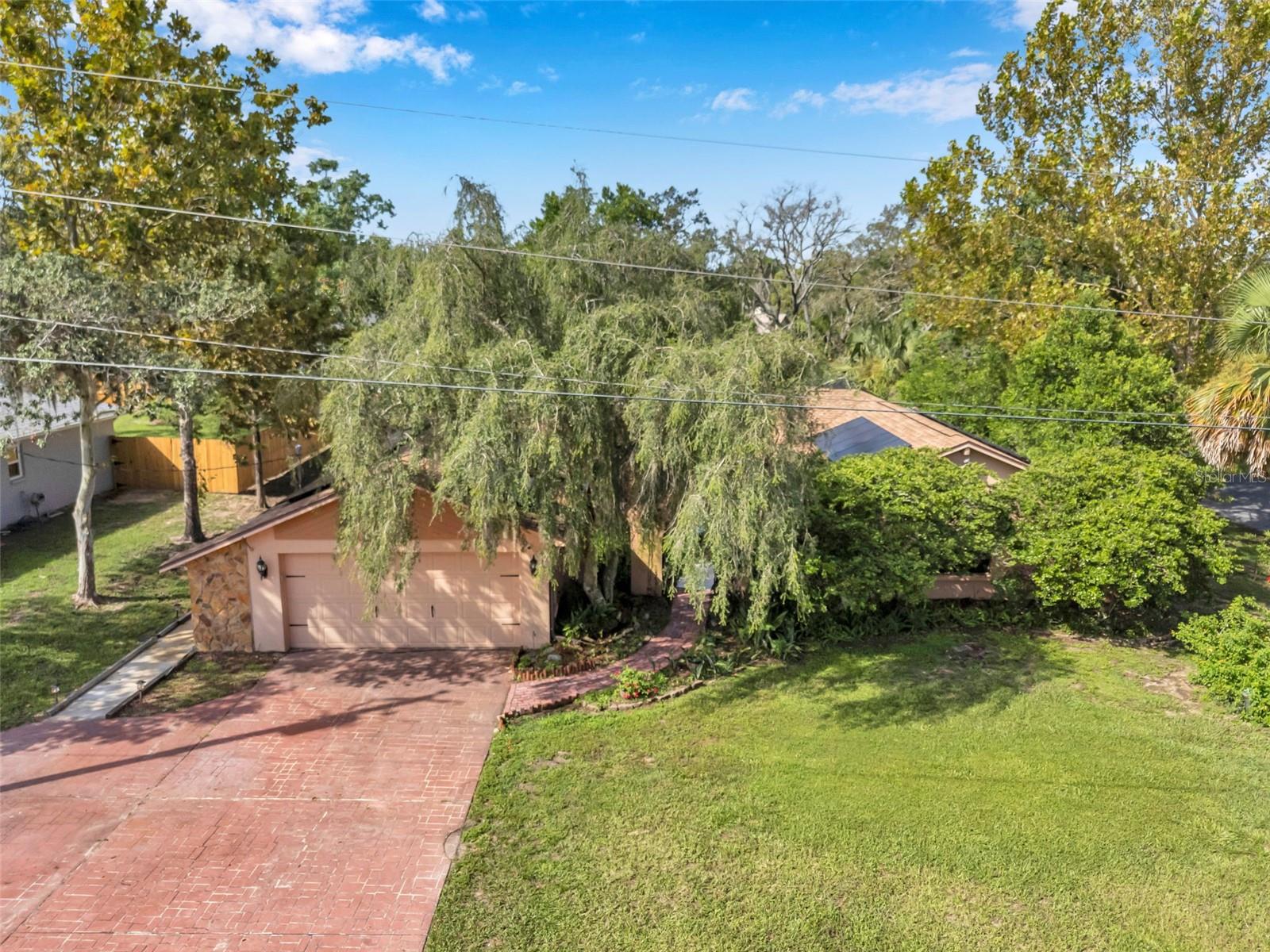 Impressive pool home with wide driveway, solar panels, private entrance with peaceful pond and rock stream on a corner homesite with no immediate neighbors across the side street.