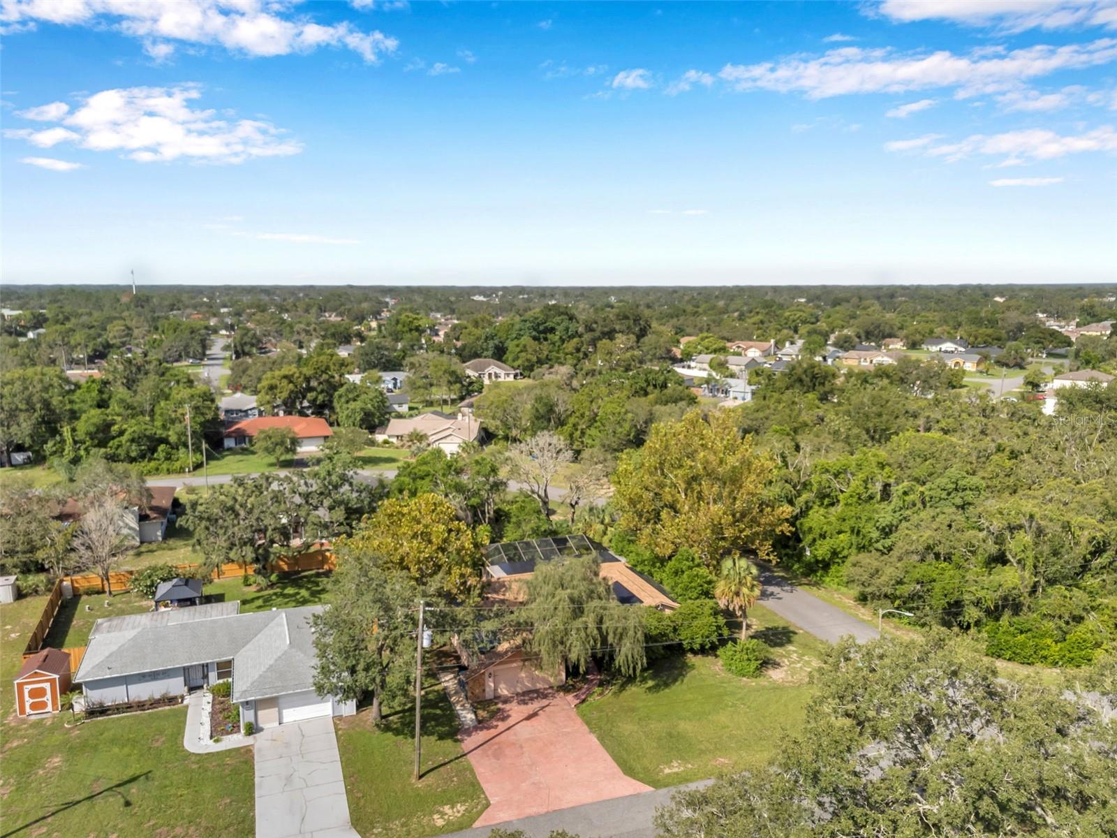 Impressive pool home with wide driveway, solar panels, private entrance with peaceful pond and rock stream on a corner homesite with no immediate neighbors across the side street.