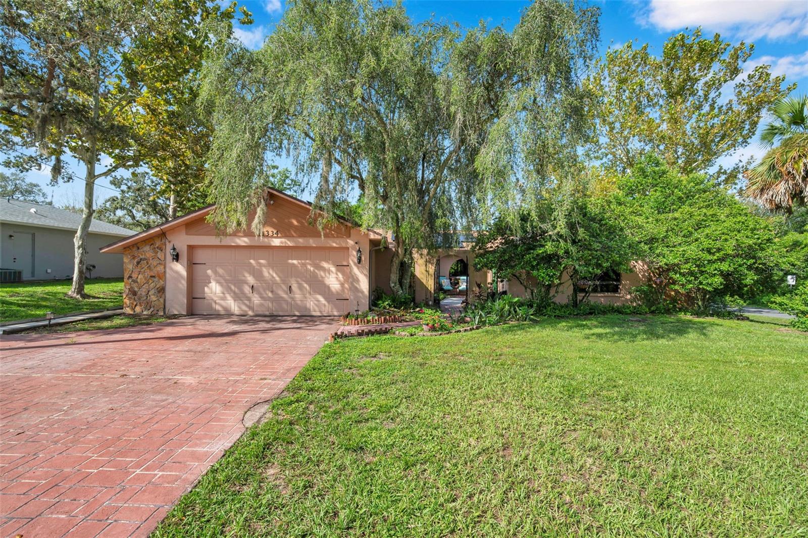 Impressive pool home with wide driveway, solar panels, private entrance with peaceful pond and rock stream on a corner homesite with no immediate neighbors across the side street.
