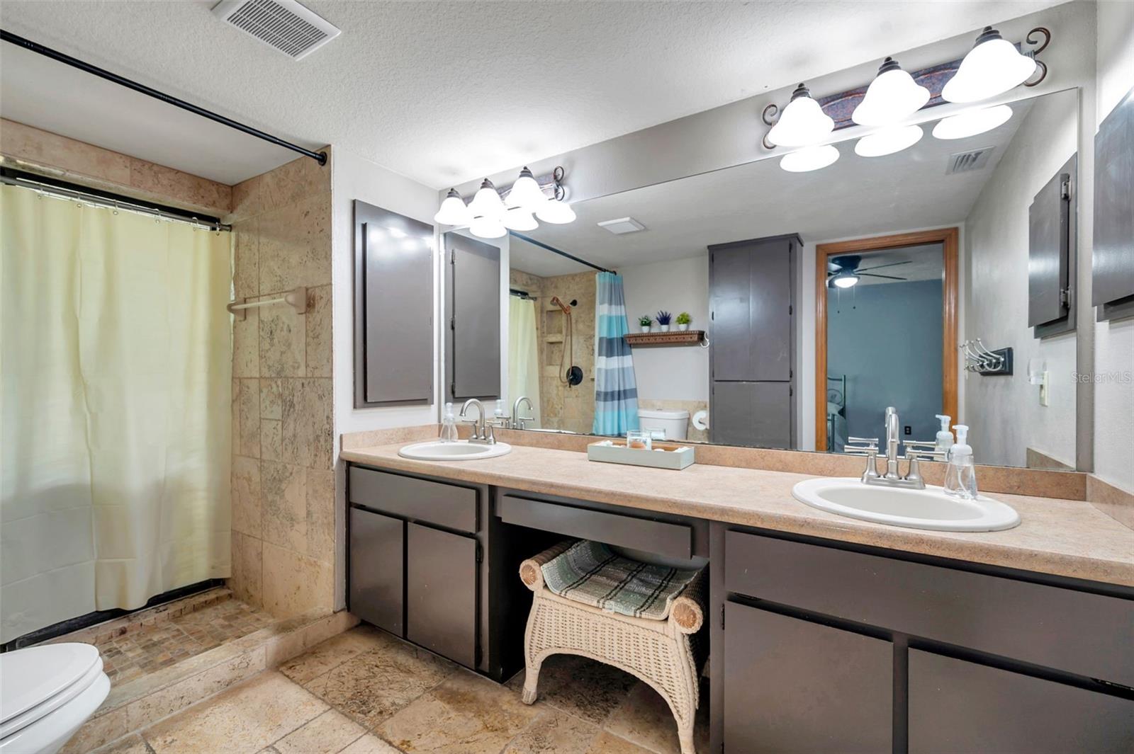 Primary bathroom with double sinks and a walk in shower