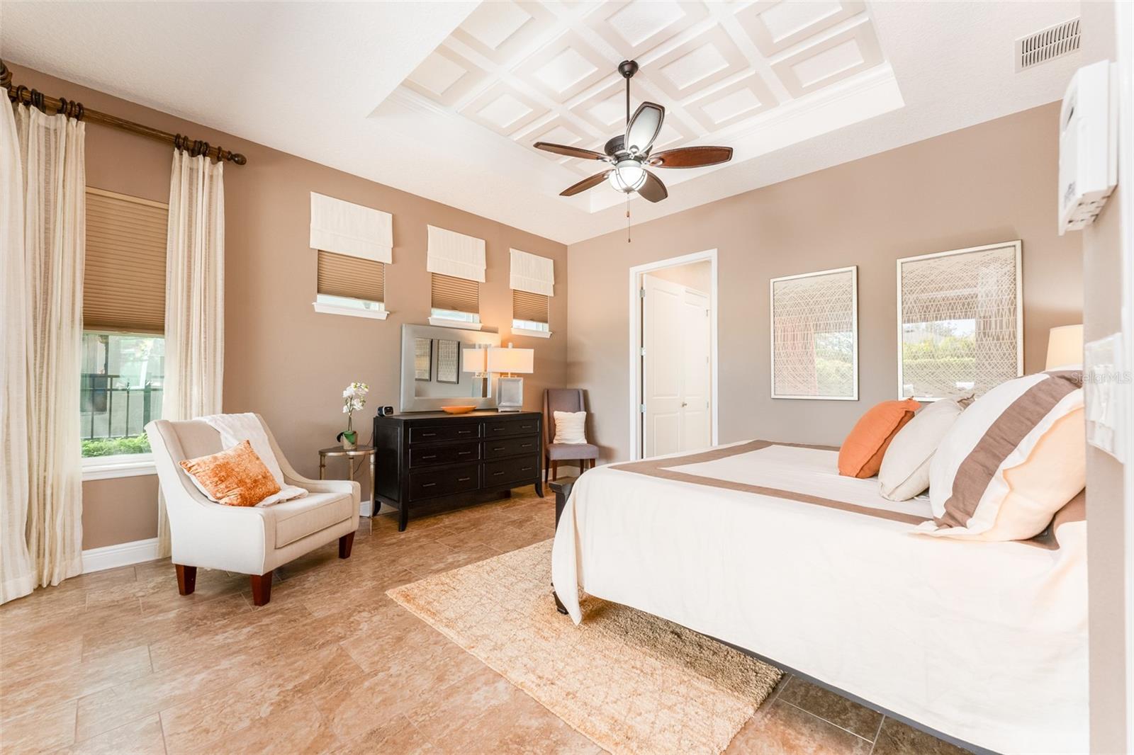 Primary Suite with Access via Sliders to the Outdoor Living Space. Notice the decorative coffered ceiling