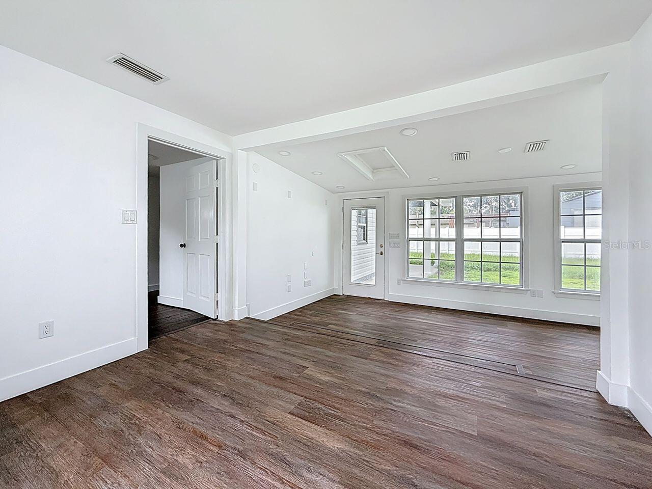 From kitchen dining towards back door primary bedroom door