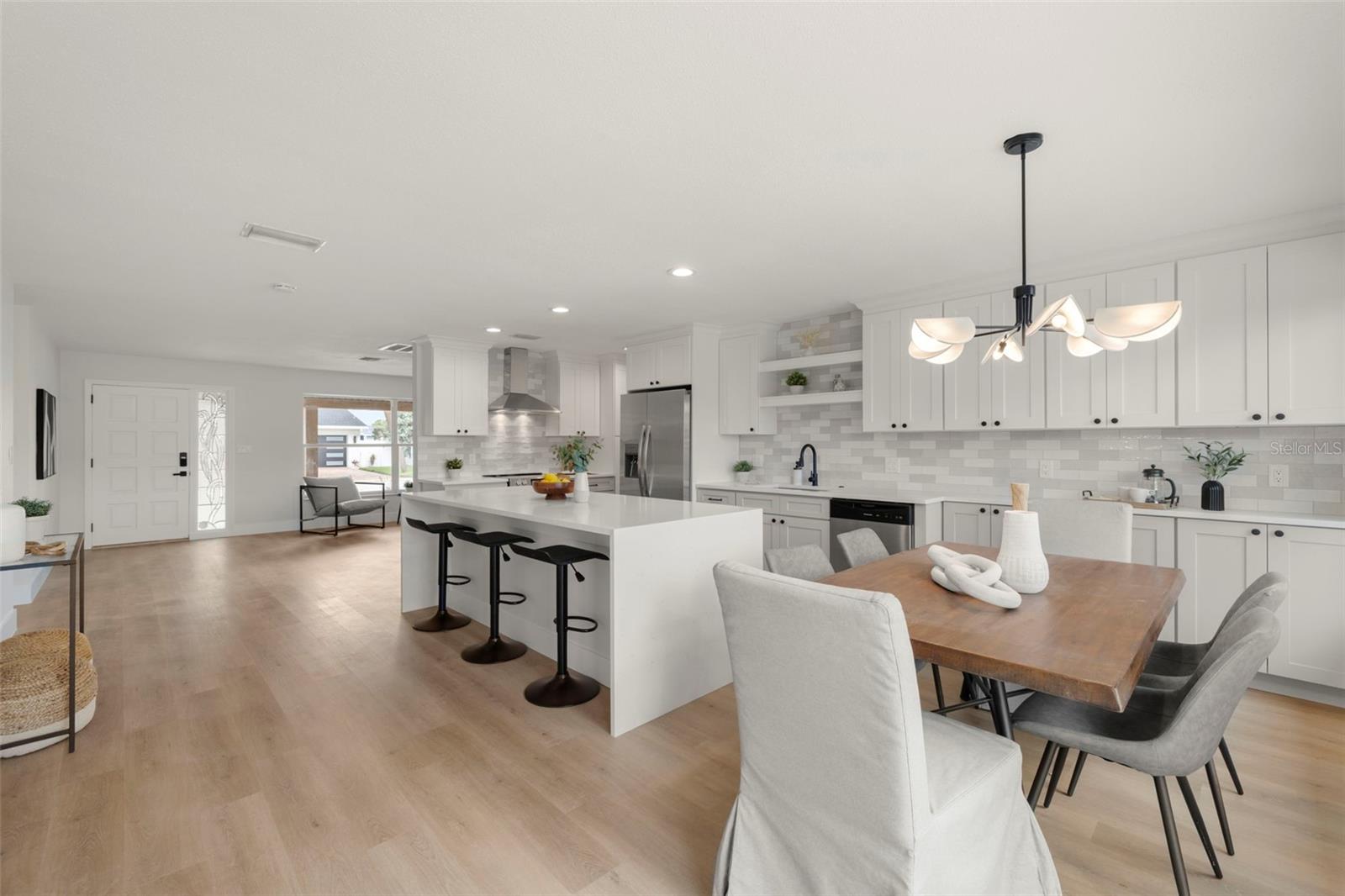 Chef's dream kitchen with dual waterfall edge Quartz counter top, ss appliances, subway tile backsplash