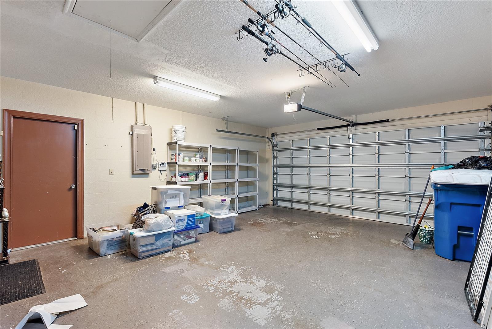 2 car garage with shelving and cabinets for storage, plus attic