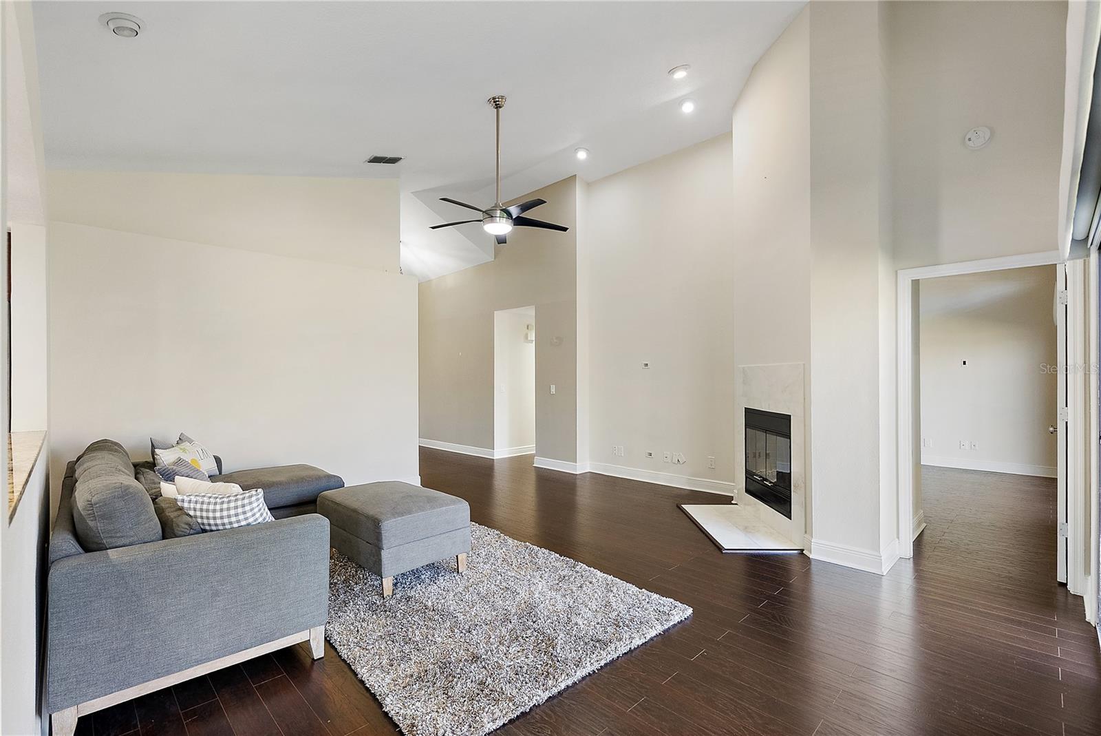 Large great room pot shelf and wood burning fireplace, soaring ceilings, nice looking dark laminate flooring
