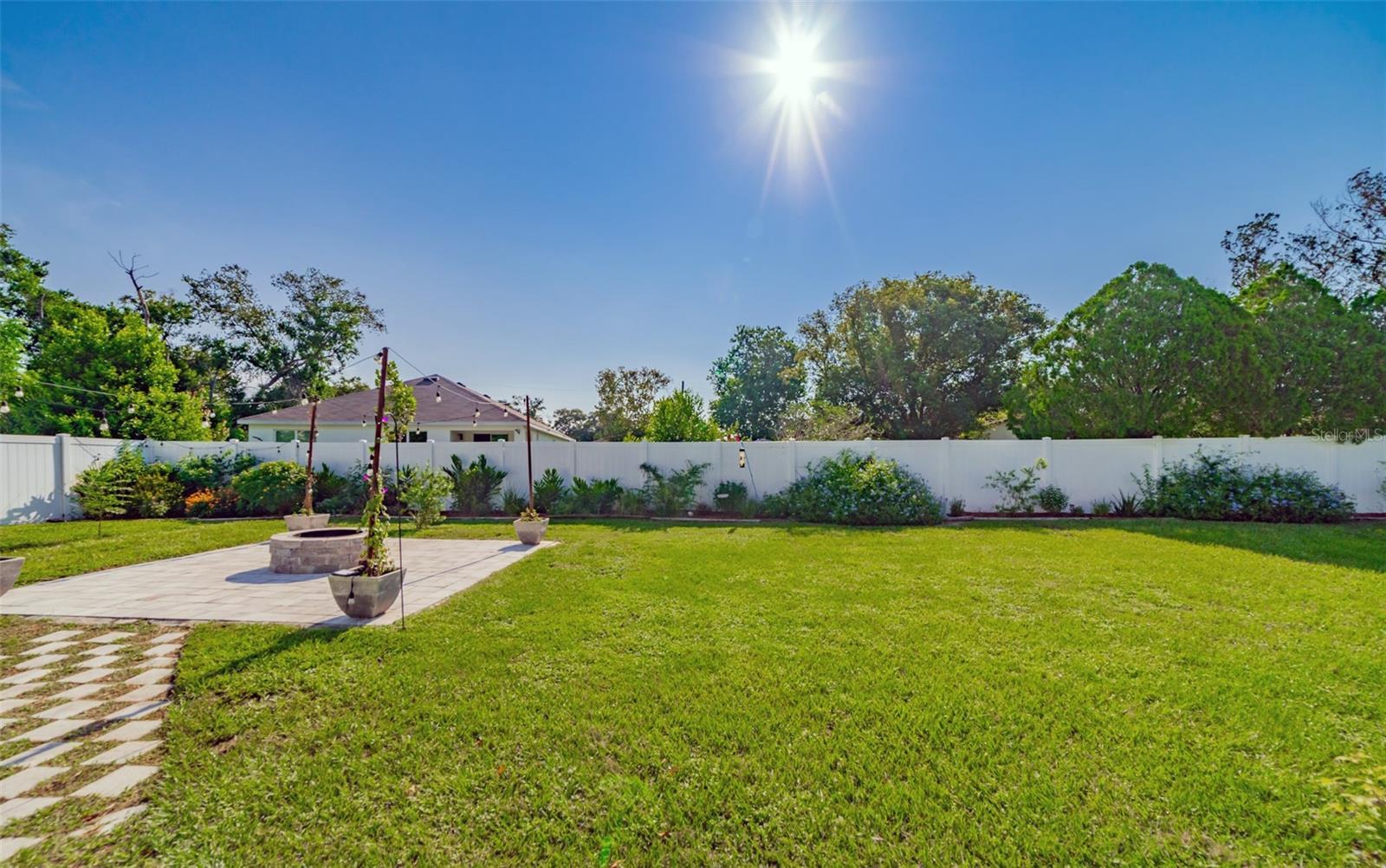 Newer PVC Privacy Fence with Flowering Plants & Blueberry Bushes
