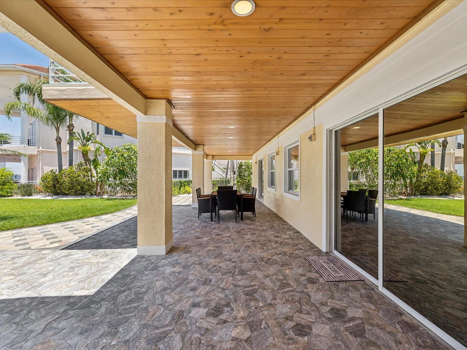 Covered patio with steps leading from upper areas and direct access to 8 car garage