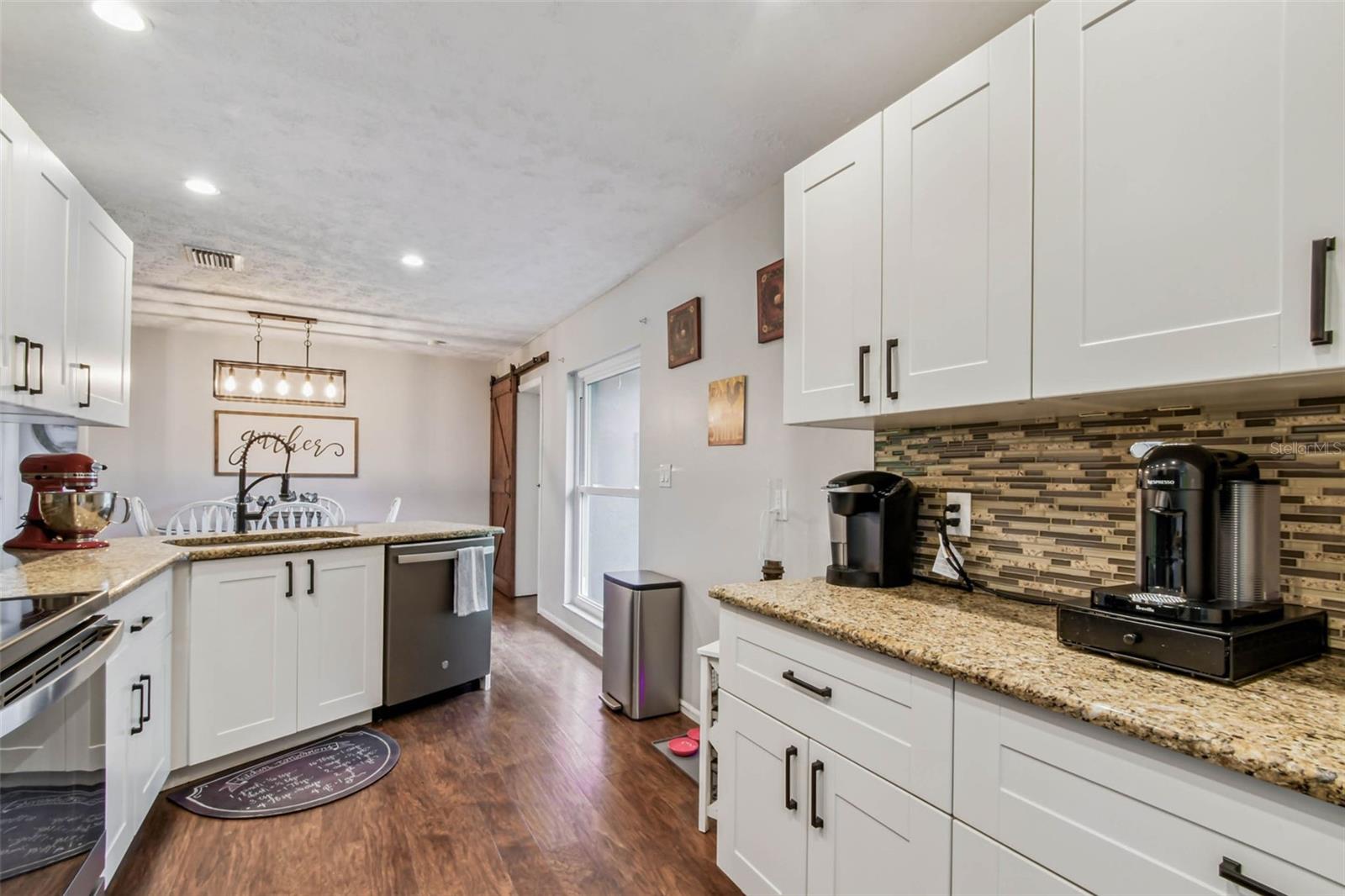The granite countertops and backsplash coordinate beautifully to curate a warm and homey feeling, and the oversized window enhances that with by letting in a ton of natural light.