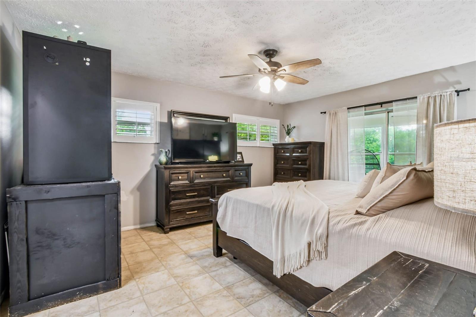 The primary suite has plantation shutters and a modern board and batten accent wall with a built-in shelf.