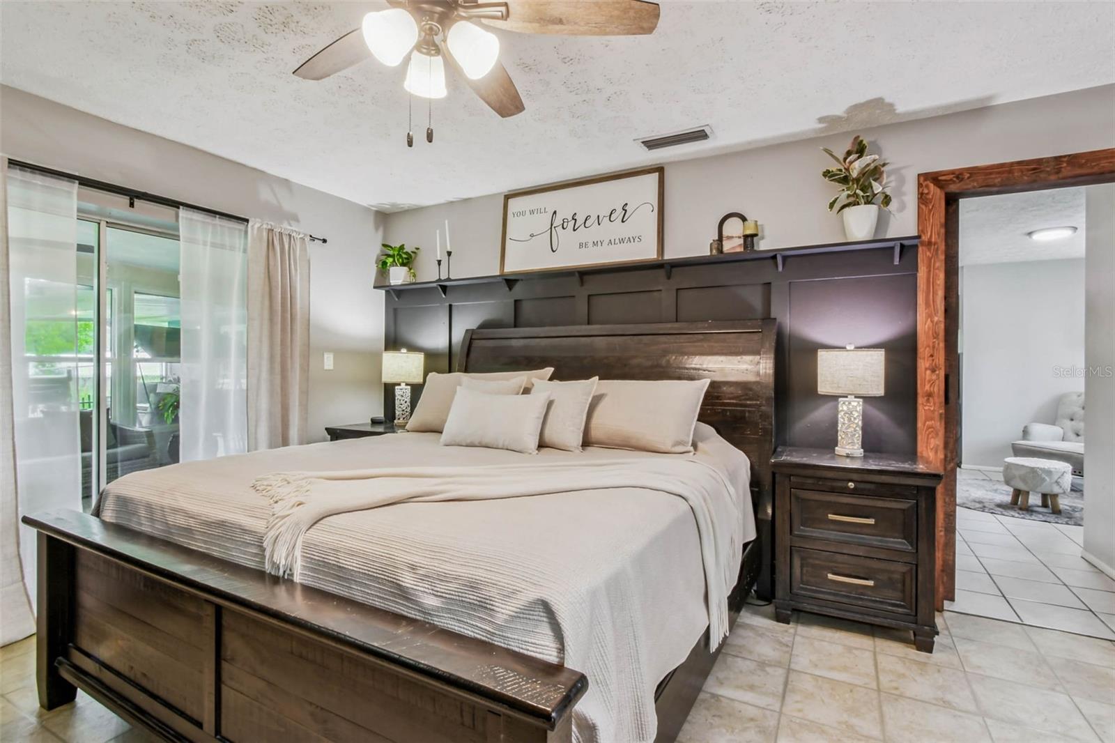The primary suite has plantation shutters and a modern board and batten accent wall with a built-in shelf.