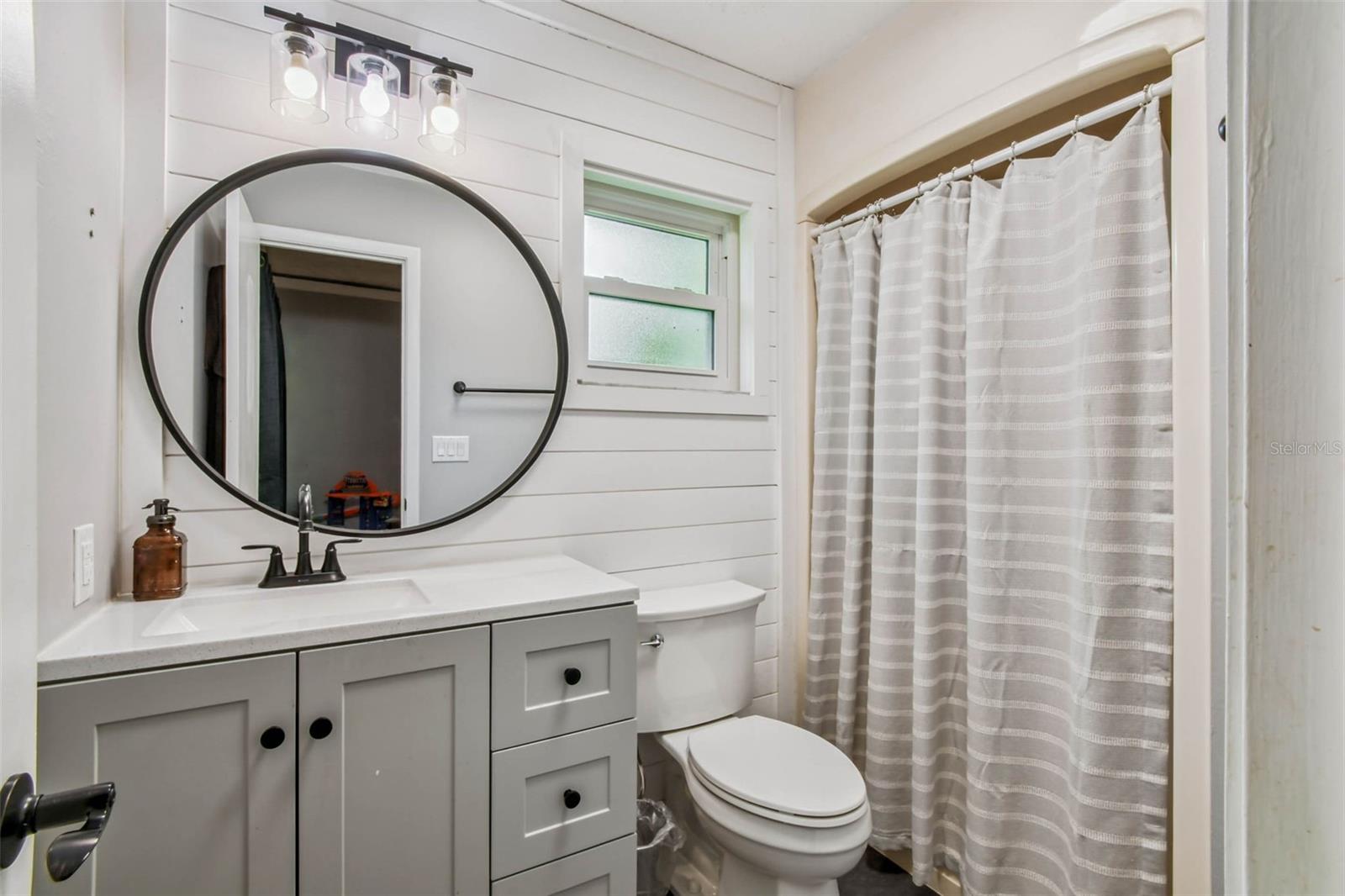 The bathroom in the secondary suite has been recently refreshed with a new toilet, oversized vanity, bronze fixtures and a classic shiplap wall that adds so much character.