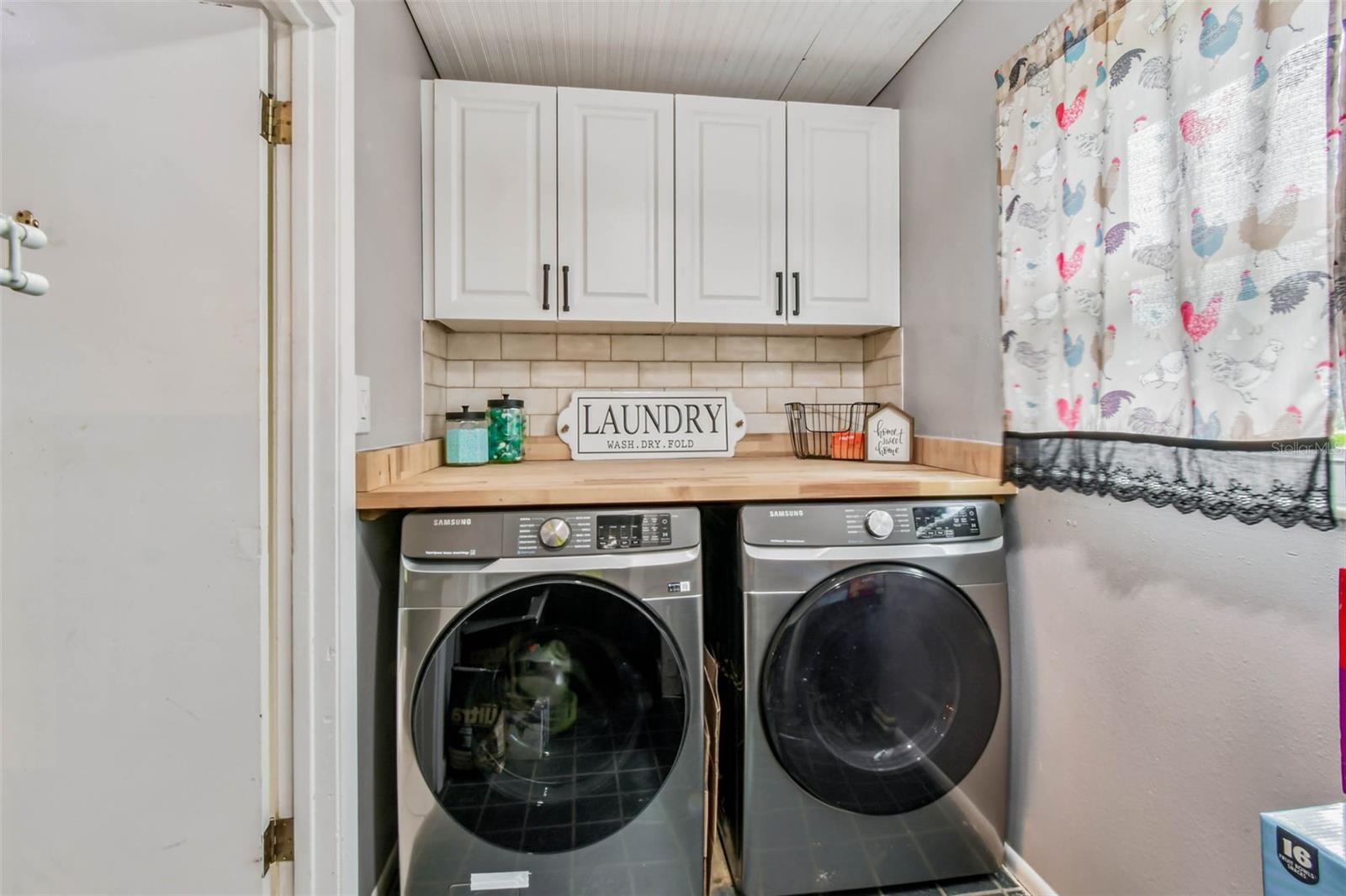 The laundry room has built-in shelving and cabinetry for maximum functionality.
