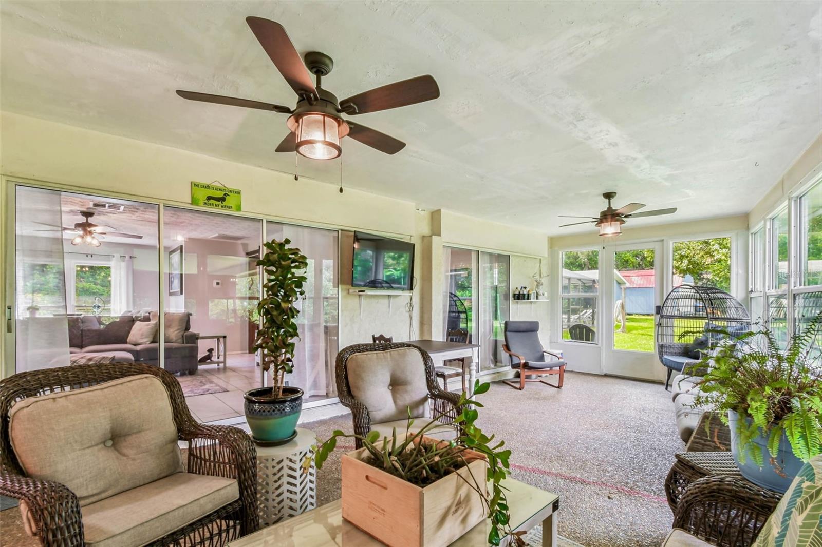The dining room, living room, and primary suite all have sliders that open to this stunning Florida Room!