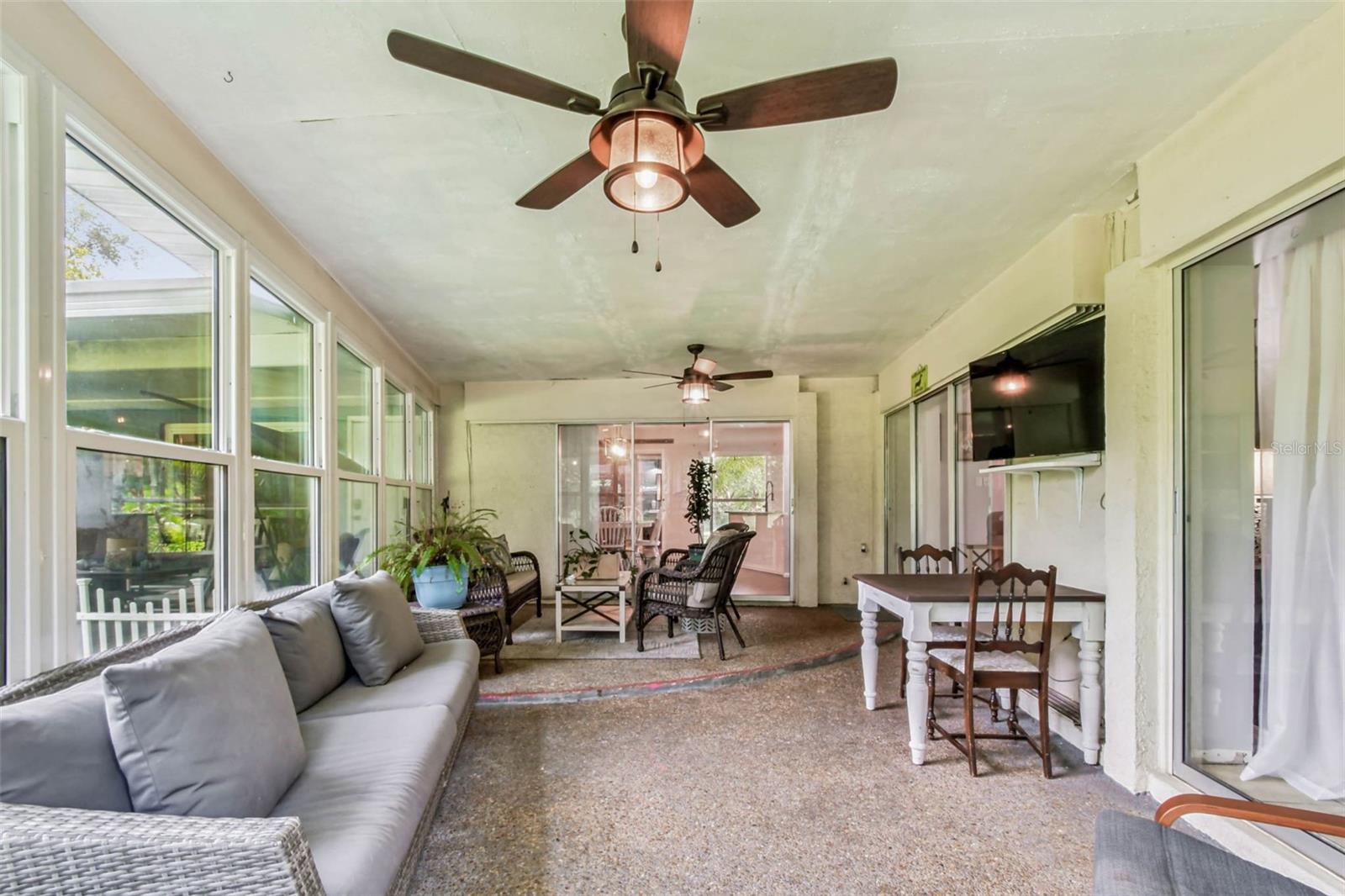 The dining room, living room, and primary suite all have sliders that open to this stunning Florida Room!