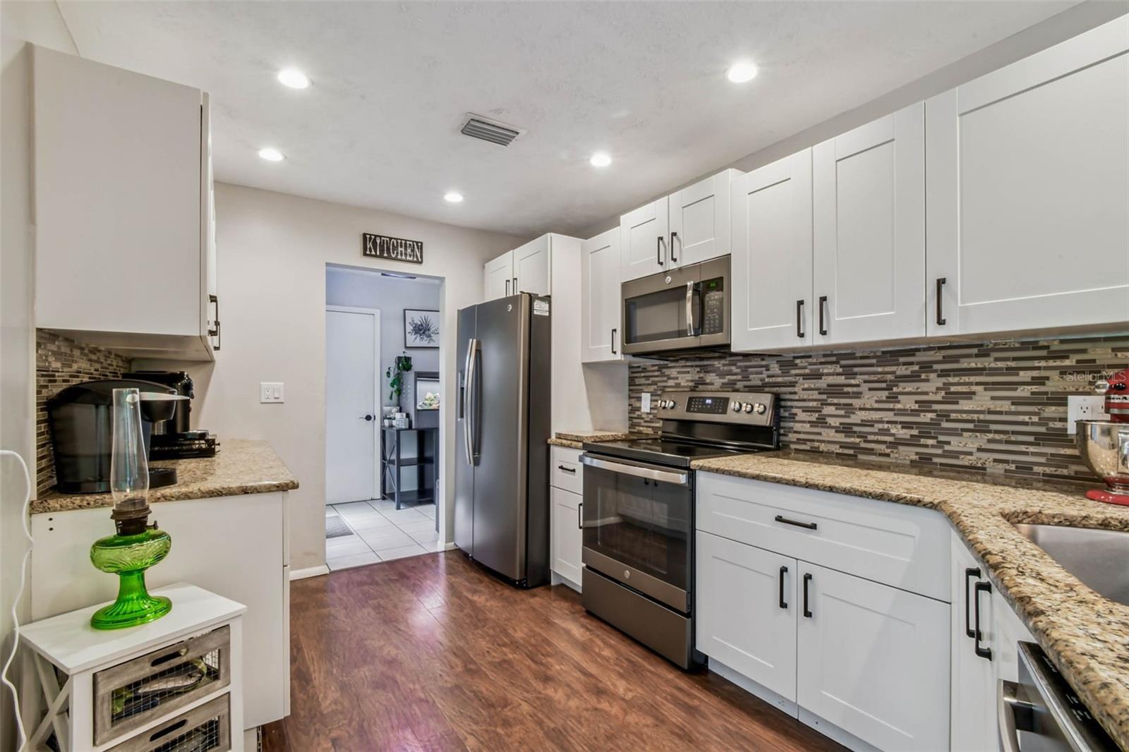 The kitchen has striking, bronze cabinet hardware and a high-end sink fixture to match.
