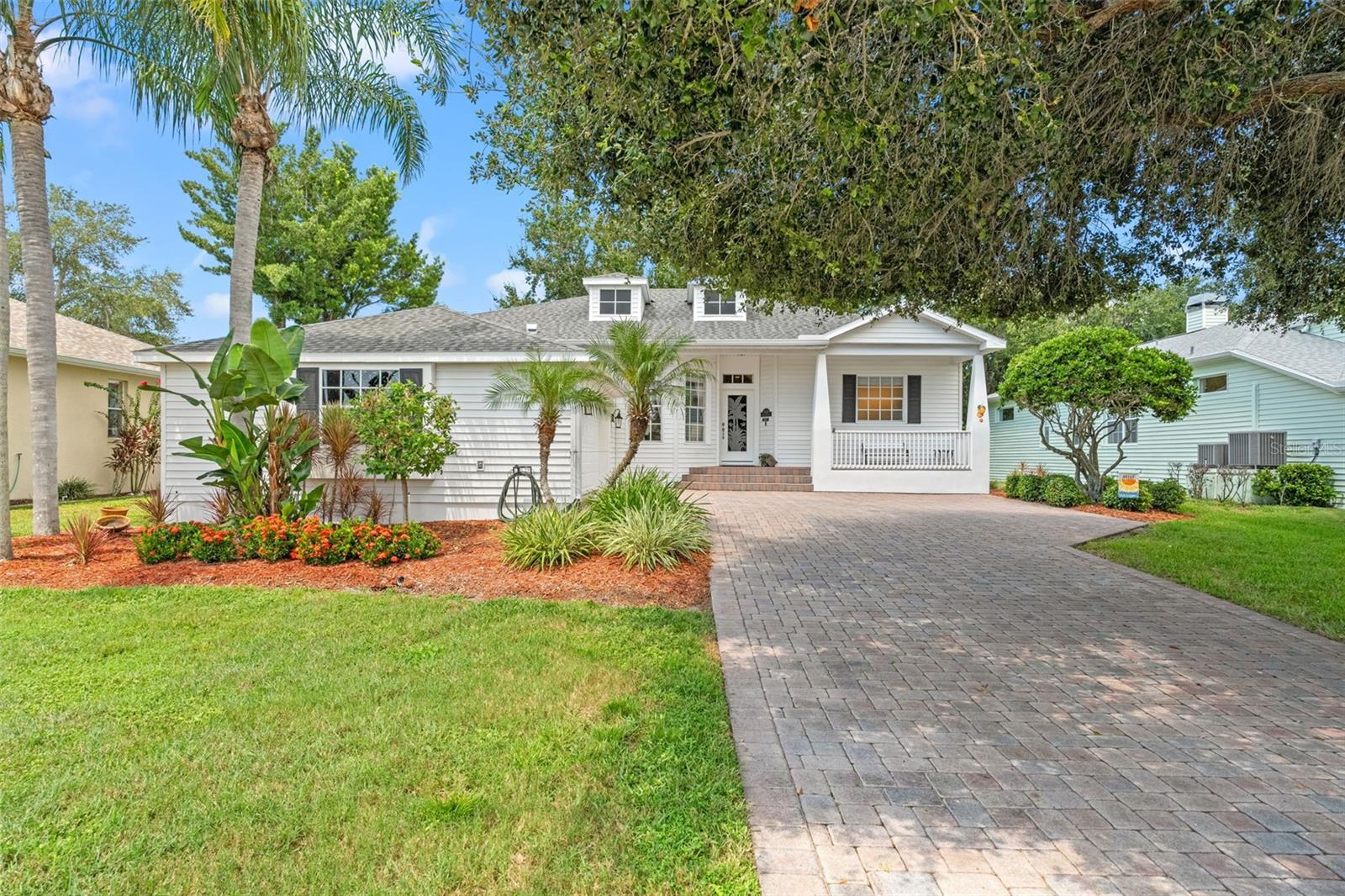 Manicured yard and vibrant landscaping enhance the home’s Florida charm.