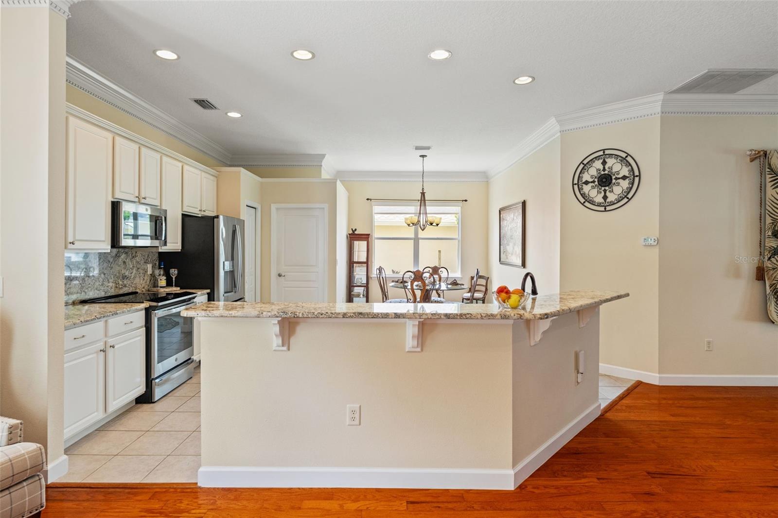 Updated kitchen features granite countertops, a large breakfast bar, and plenty of room for casual dining.