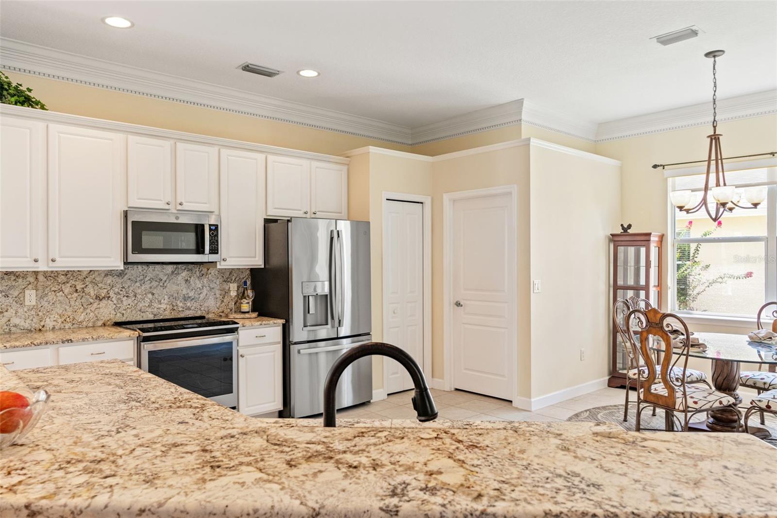 Stainless steel appliances, granite backsplash, and crisp white cabinetry provide a modern, timeless look.