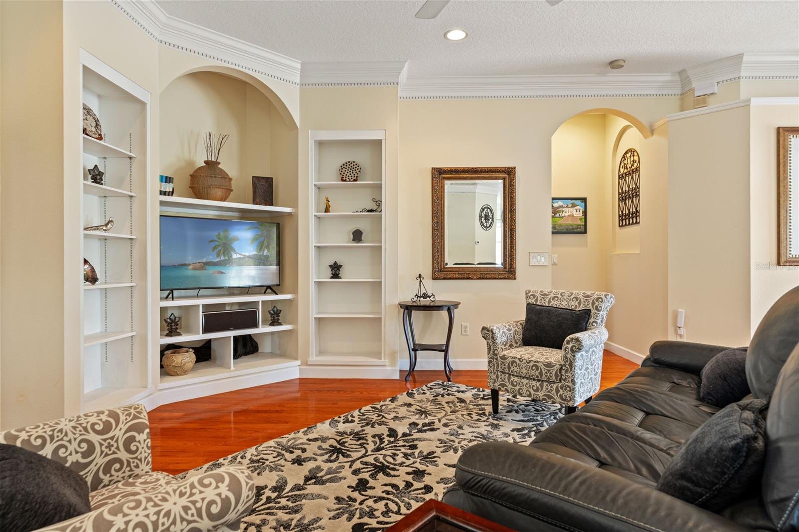 Custom built-in shelving surrounds the media wall, offering both style and function.