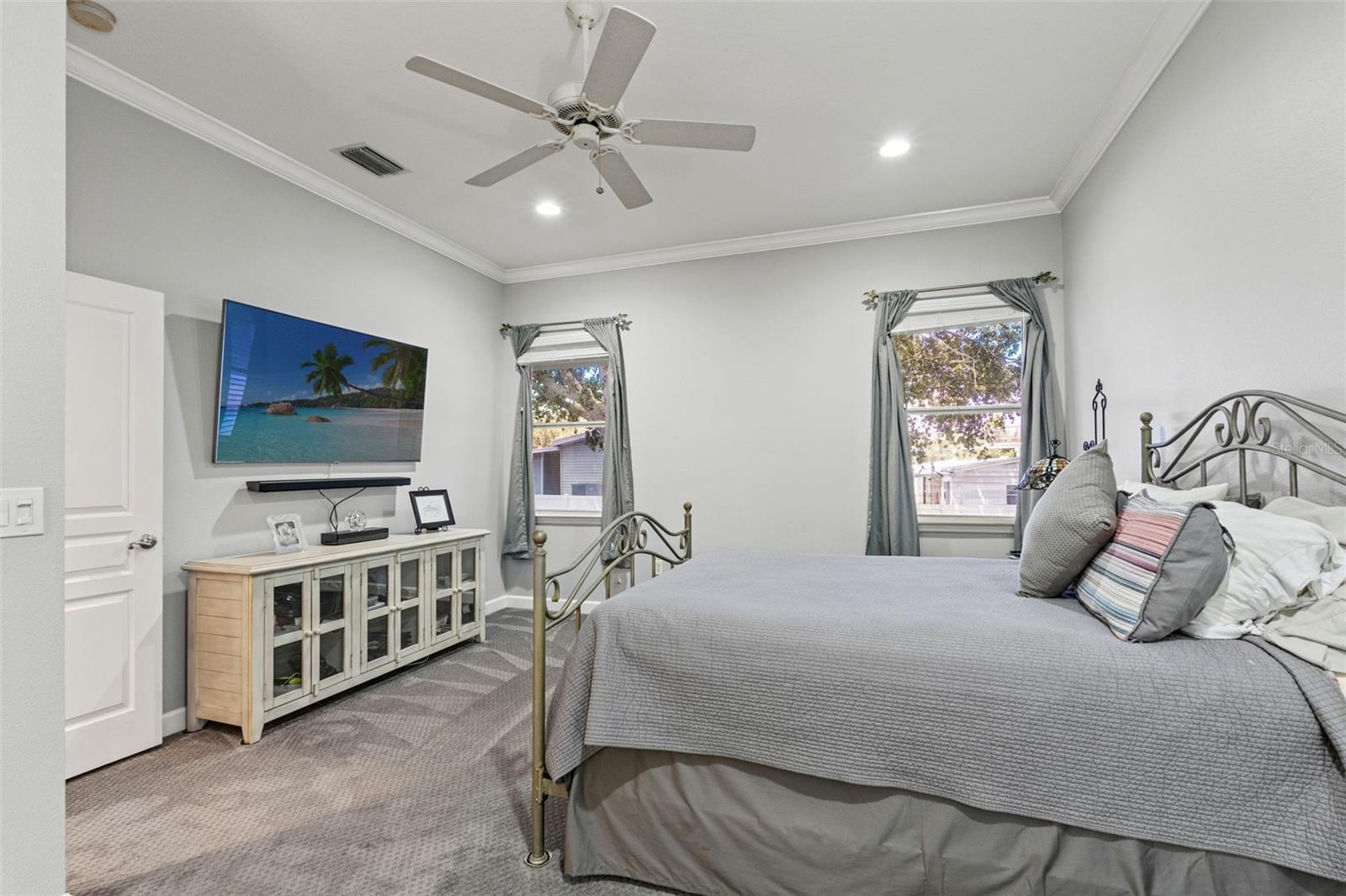 Spacious retreat with ceiling fan, recessed lighting, and neutral palette.