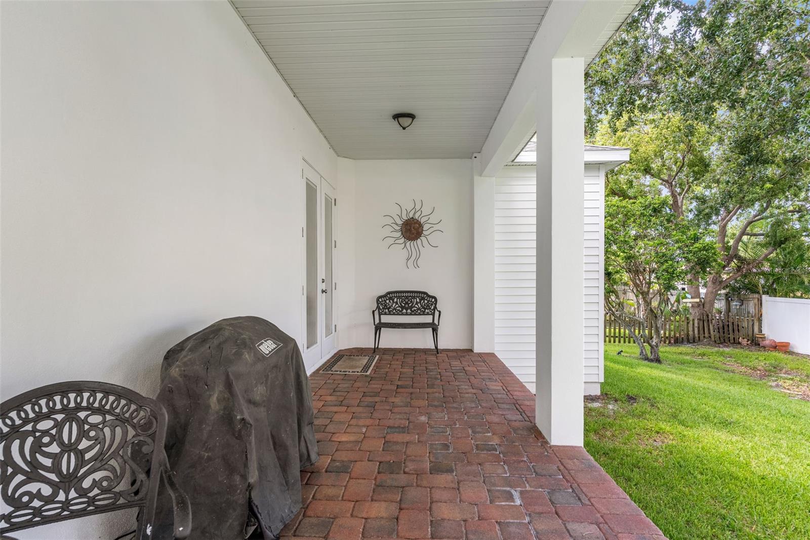 This paver-lined covered patio is perfect for grilling, dining al fresco, or simply relaxing in the shade.