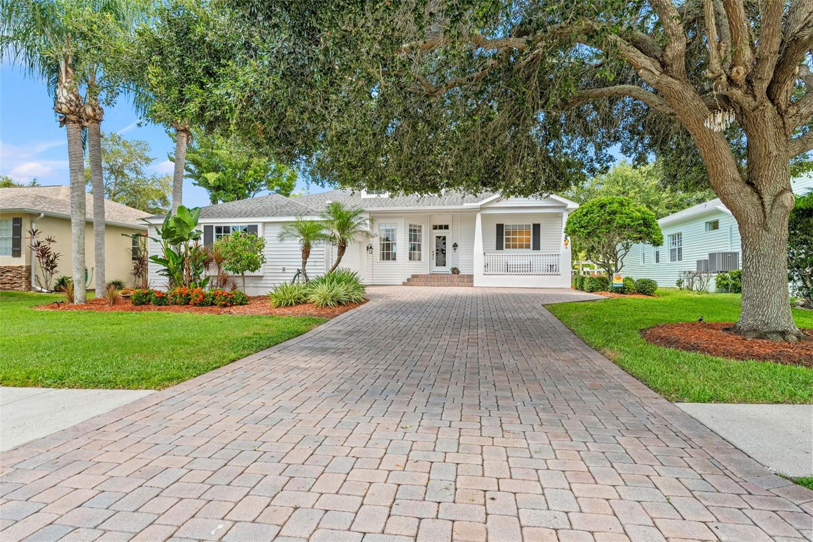 Well-maintained exterior with fresh landscaping, single front entry door with hurricane proof etched glass, and a welcoming front porch.