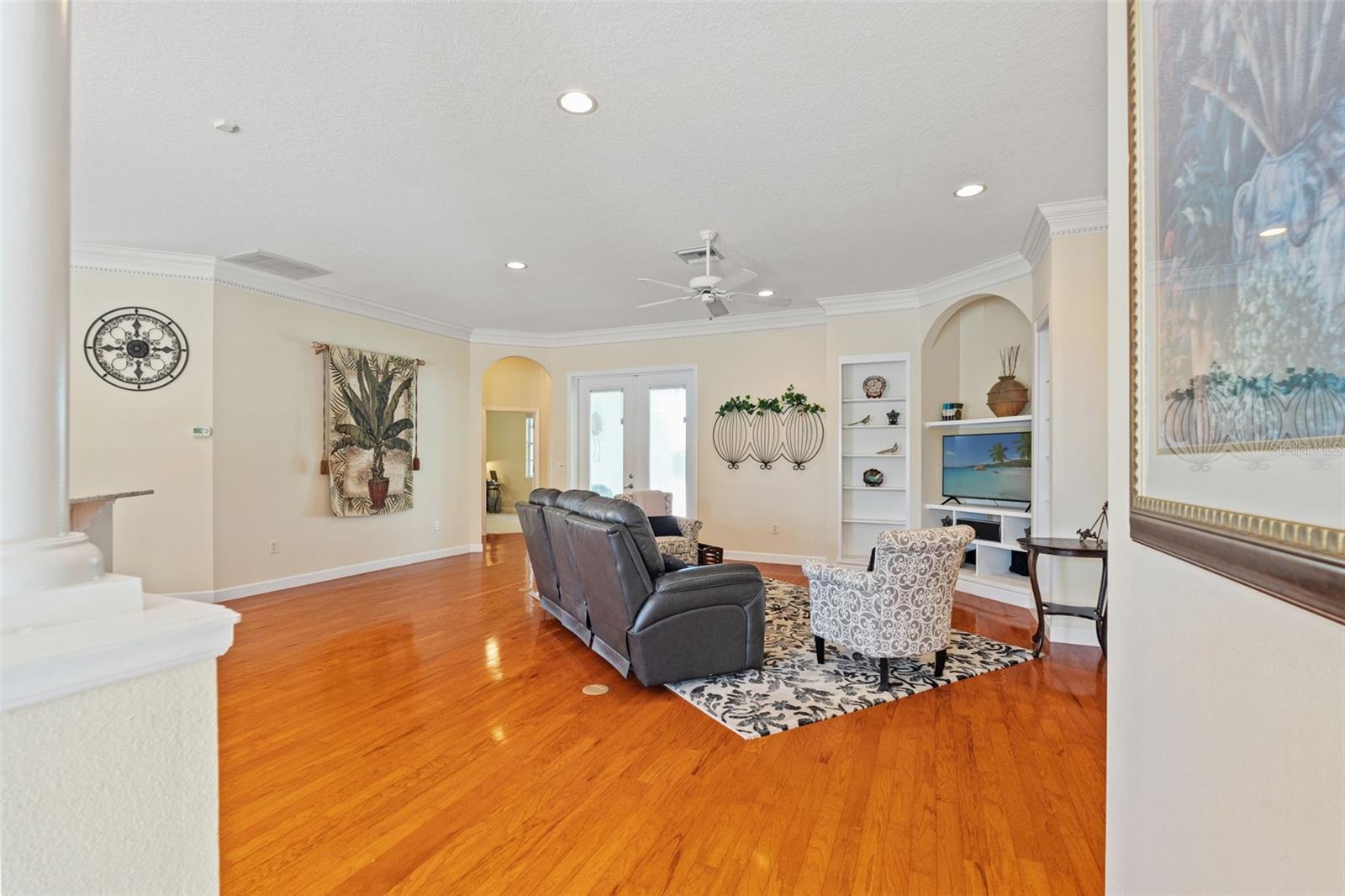 Spacious living area with crown molding, recessed lighting, and custom built-ins that add both character and storage.