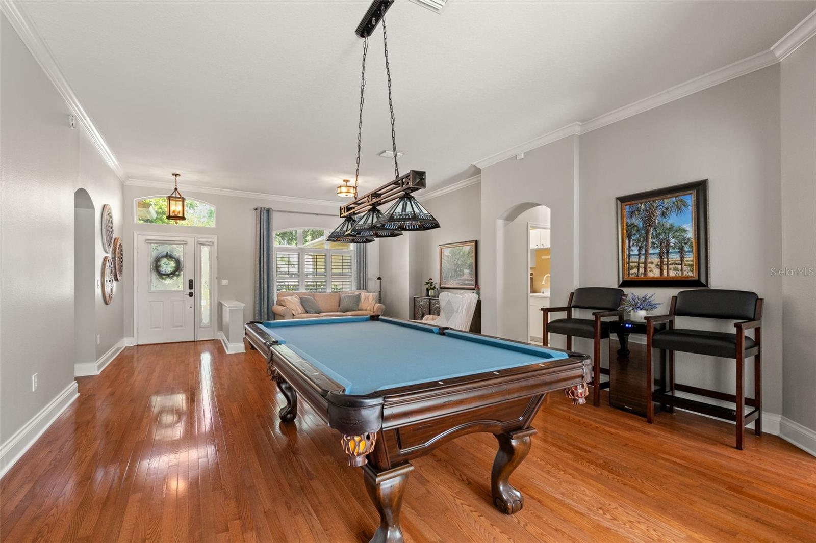 Looking toward the front door, this angle highlights the natural light, detailed trim work, and coordinated design between the front living area and the game space (dining room).