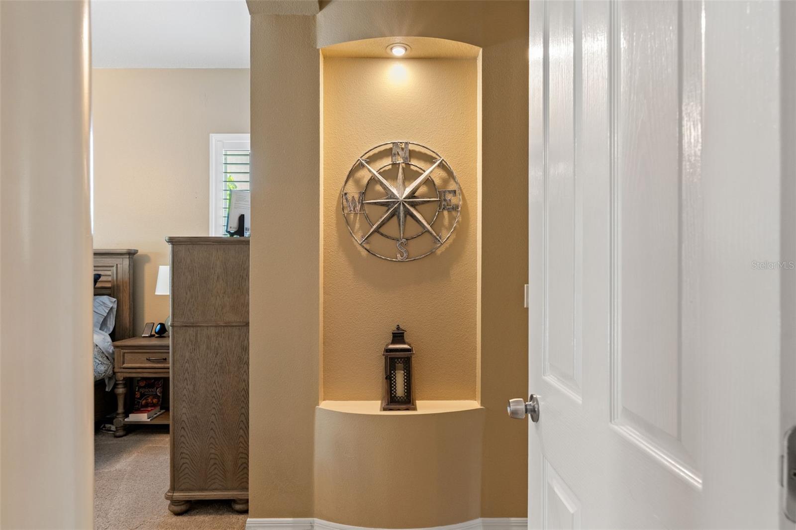 A thoughtfully designed wall niche with spotlighting adds character to the hallway, perfect for showcasing decorative pieces or artwork.