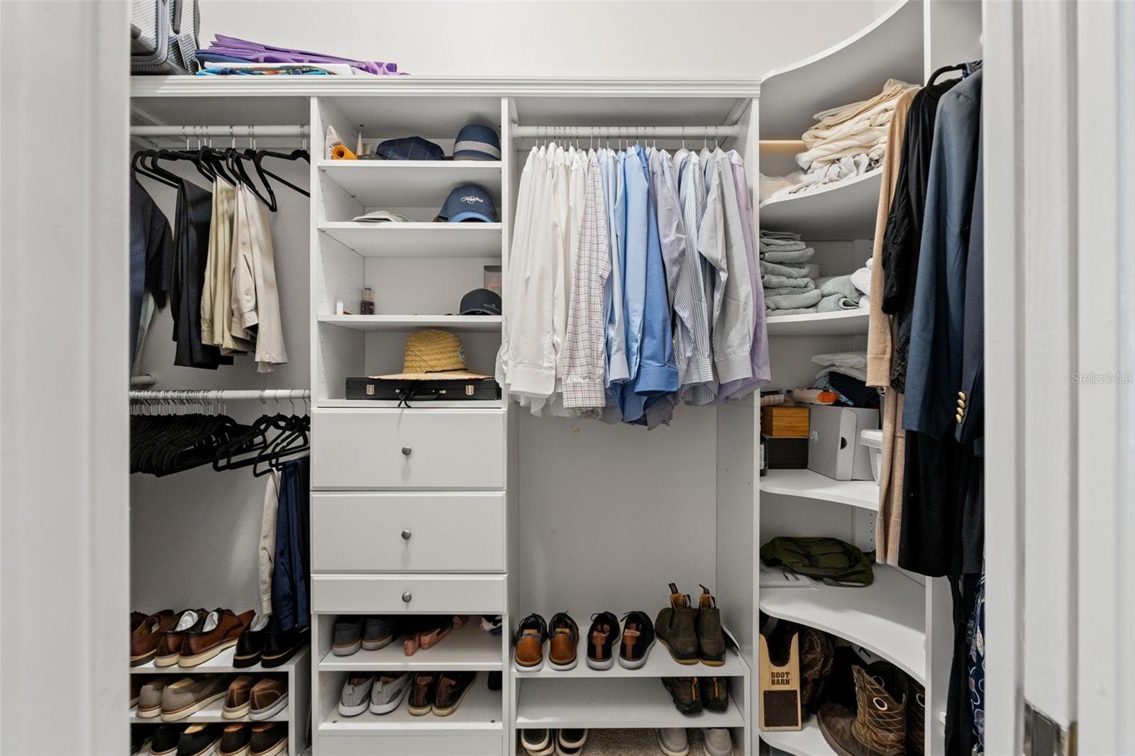 One of two custom walk-in closets, featuring built-in shelving, drawers, and ample hanging space to keep everything organized.