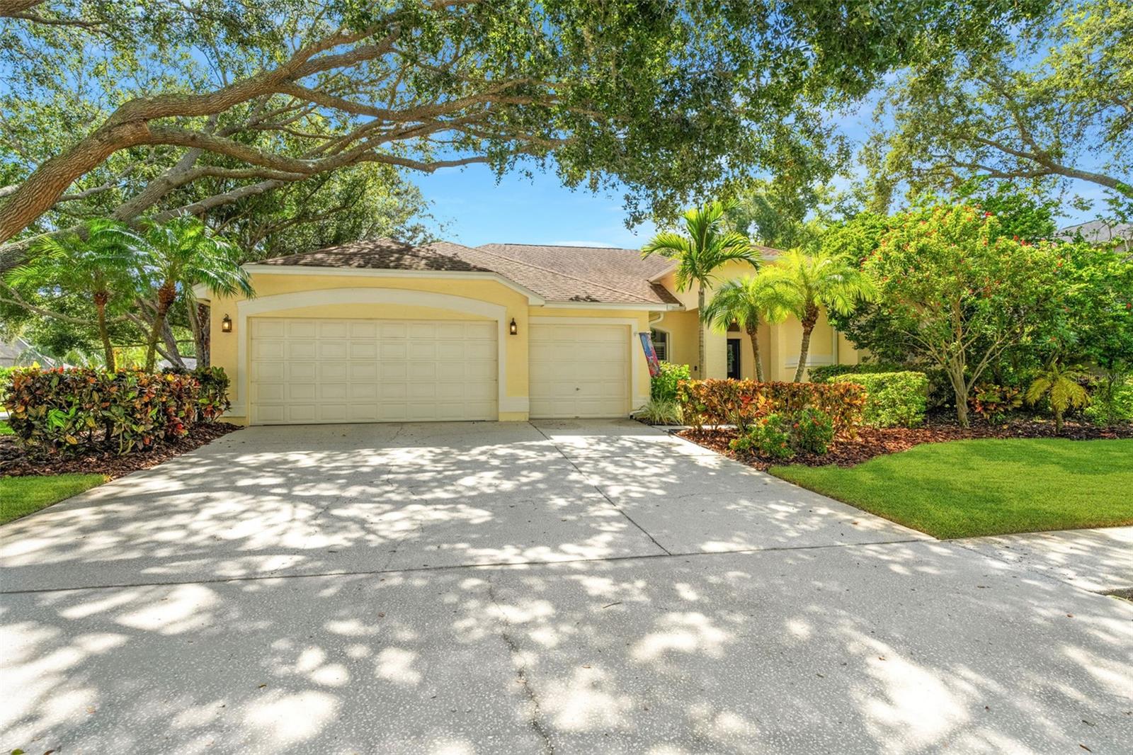 This beautifully maintained home boasts tropical landscaping, mature trees, and a welcoming presence. The lush front yard and wide driveway set the tone for a warm and inviting residence.