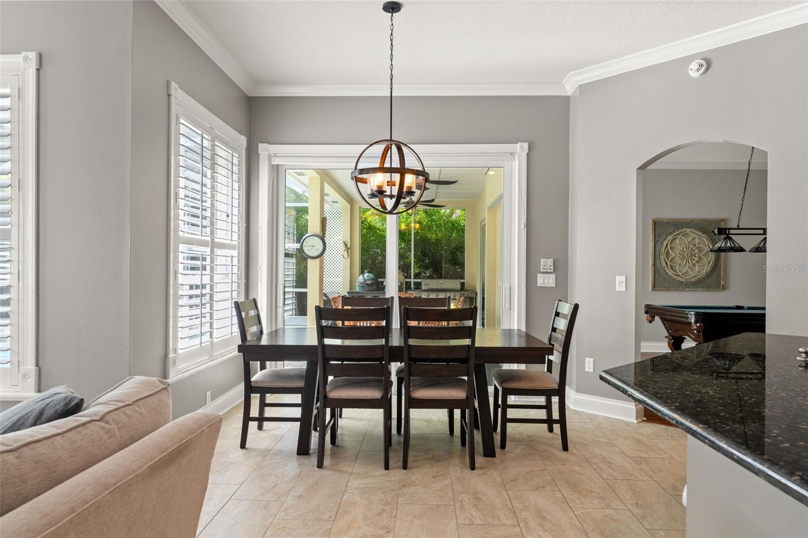 A charming nook framed by oversized windows and sliding doors, offering serene views of the outdoor living space—perfect for morning coffee or casual meals.